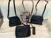 Four purses displayed on a white fabric background including three black purses and one beige purse plus one brown eyeglasses case