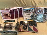 Photo showing the full lot of pillow protectors, flannel sheet set, flat sheet, and mattress protectors in packaging.