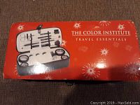 Box with red background labeled The Color Institute Travel Essentials with image of the travel grooming kit inside.