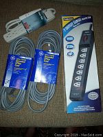 Top view of four extension cords and surge protector, showing packaging and labels.