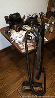 Full setup of Rainbow vacuum cleaner with hose and attachments standing upright near table with various small home appliances and electronics.