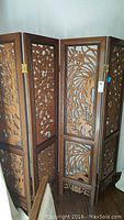 Four-section carved wood folding screen with detailed Asian-inspired carvings, standing 71 inches tall.