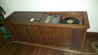 Full front view of walnut veneer console cabinet with paneled facade and right-side speaker grill