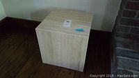 Granite pedestal square block about 14 inches wide shown on wooden floor.