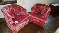 Two rose pink velour swivel club chairs angled slightly toward each other matching the seller's description