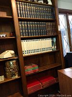 Bookshelves showing multiple sets of books including the Scribners Radio Music Library, Encyclopedia Americana, Book of Knowledge, and some red Time Life Cookbooks