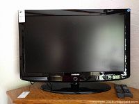 Front view of the 37-inch Samsung TV with screen turned off and remote placed in front