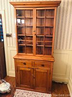 Front view of two-piece pine hutch showing upper glass doors and lower drawers