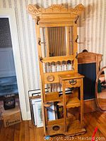 Full view of the antique oak hall stand coat rack showing mirror, hooks, drawer, and decorative woodwork.