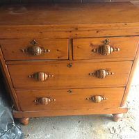 Front view showing four drawers and carved turned drawer pulls