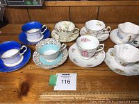 Overview showing seven assorted fine bone china tea cups and saucers with varying floral and colored designs