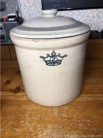 Front view of beige 2 gallon Crown crock with lid, displaying crown logo and '2 GAL' marking.