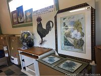 Multiple pieces of wall art including two large framed prints, smaller floral framed prints, and the 'L'Art Culinaire' poster displayed over drawers and boxes.