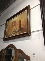 Large framed painting showing Native American chief ghost image over desert landscape with riders and rock formations in sepia tones