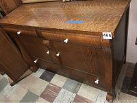Front angled view of vintage wood dresser showing wood grain finish and white knobs.