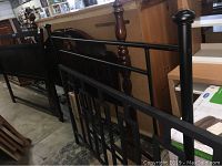 Four headboards stacked side by side and leaning against furniture pieces in a warehouse or store setting, showing different styles and material types.