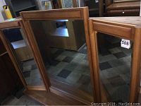 Front view of wooden framed trifold dresser mirror, showing the three mirror panels and wooden frame.