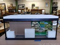 Front view of new reptile tank with foam padding and green label for Repto Filter inside the tank.