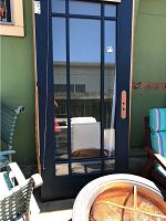 Blue metal framed door with glass panels in French style, shows full door front view with blue paint and reflective glass.