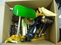 Box with green desk lamp and various wood carvings including turtle, dog, and small bird