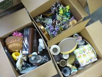 Three open boxes filled with assorted decorative and household items.