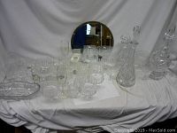 Overview of the full selection of glassware and the mirror arranged on a white fabric backdrop.