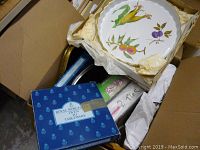 Top view of box with Royal Worcester Evesham ceramic serving tray featuring botanical illustrations and partially visible box labeled Royal Worcester China Tableware.