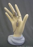 Ring and necklace displayed on plastic hand showing the design and size