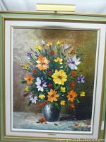Full view of the framed oil painting with colorful flowers in vase.