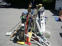Photo showing entire lot of cleaning tools grouped together outdoors under sunlight.