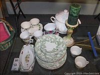 Full set photo showing Fruit Wood and Sons England china dish set including dishes, mugs, oval serving dishes, tureen and green candle on large candlestick.
