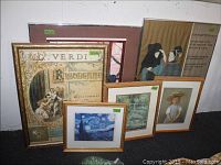 Six framed art prints of various sizes displayed leaning against a wall with visible moisture damage on print surfaces.