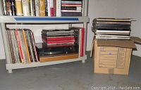 Shelf view showing Thorens turntable beneath and vinyl albums stored vertically on either side