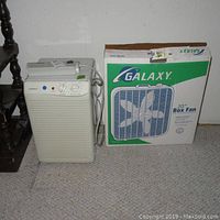 GoldStar humidifier and Galaxy 20-inch box fan in original box shown side by side on carpeted floor