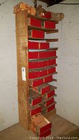Photo showing a wooden organizer rack holding multiple Robert Burns Cigarillos cardboard boxes, some empty with red interior.