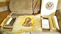 The lot as displayed on a couch with all the items laid out including the Great Seal prints, vintage newspapers, photos, poster, and silk print of Miss Laurette Taylor.