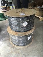 Two wooden cable spools stacked in garage