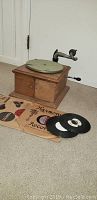 Front angled view of the Victor Talking Machine VV-IV phonograph with several 78 RPM records and sleeves placed in front of the machine.
