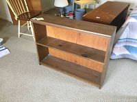 Full view of the small rustic wooden bookcase showing two shelves and overall structure.