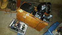 View of wooden toy chest with flight joystick and driving wheel controllers on top, and plastic bin with PC game cases by the side.