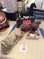 Overview photo of all four animal sculptures on table, showing the lion, horse, cat and dog figures