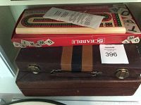 View of Scrabble box, wooden cribbage box, backgammon set, and antique poker chest stacked