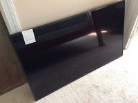 Front view of the 48-inch Samsung TV leaning against a wall