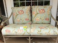 Front view of loveseat with floral cushions