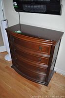 Front view of the Bombay dresser showing four drawers closed and curved facade.