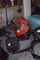 Orange Craftsman shop vacuum with black hose, orange extension cord, and black carrying case nearby.
