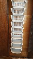 9 stackable white plastic bins placed vertically