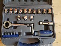 Top view showing ratchet wrench, sockets, and screwdriver bits organized in gray plastic case