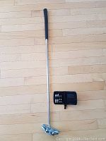 Full view of right-handed Two Bar Mallet putter with grip, shaft, and mallet head next to black pouch with weights.