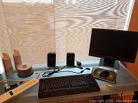 Photo of Lenovo monitor, Logitech speakers, Microsoft wireless keyboard and mouse, power strip, USB hub, dust remover cans, blank CDs and mouse pads arranged on a desk.